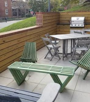 a patio with a table and chairs and a grill